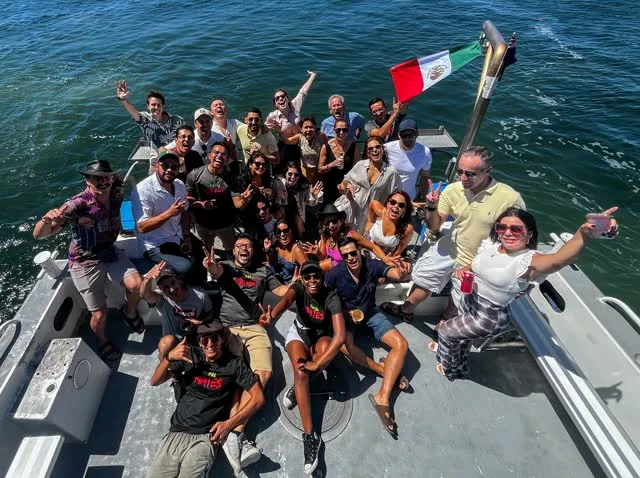 La comunidad de NopalMates a bordo del bote en el río Swan, con la bandera de México en alto